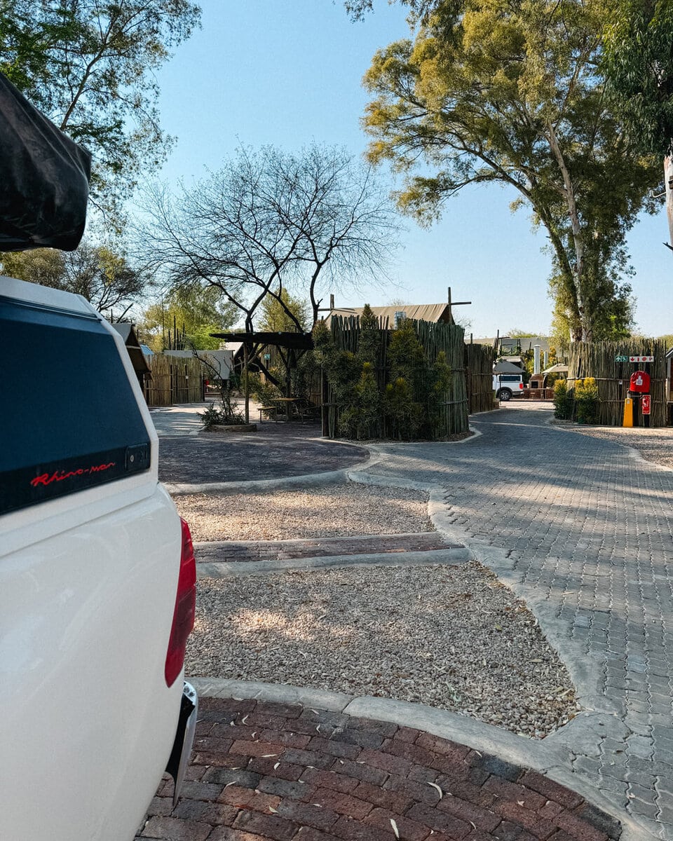 Paved paths and reed fenced pitches at Urban Campsite in Windhoek